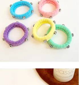 Détail de cinq chouchous élastiques aux couleurs pastel ornés de strass brillants