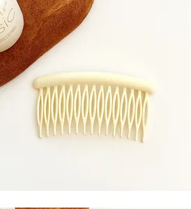 Detail view of cream beige matte finish hair comb with sixteen teeth for hair styling