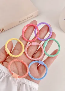 Detalle de gomas elásticas macaron de colores con textura tejida y cierres de plástico
