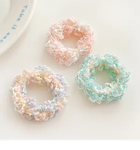 Close-up of three colorful macaron-toned elastic hair ties with textured spiral weave