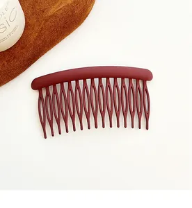 Close-up of matte dark red hair side comb with 16 teeth on a clean white background