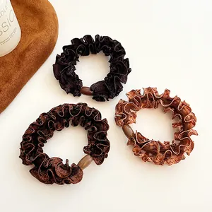 Set of three coffee-toned ruffled hair scrunchies with elegant glossy finish and beads