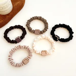 Set of 5 elastic hair ties in earthy tones with square rhinestone accents on white surface