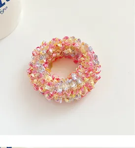 Macro detail of hand-knitted pastel ice cream color hair tie with fuzzy pom textures