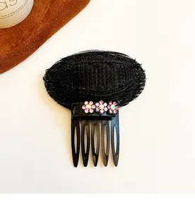 Détail du coussin volumateur noir avec fleurs en strass roses et peigne en plastique noir