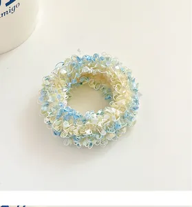 Detailed view of the soft textured blue and yellow knit fabric on a high-elastic hair tie