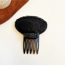 Gros plan d'un coussin volumateur à cheveux noir avec peigne et perles décoratives
