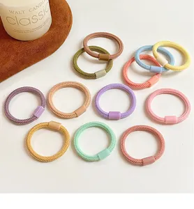 Détail d'élastiques à cheveux colorés aux tons Morandi avec texture tissée durable