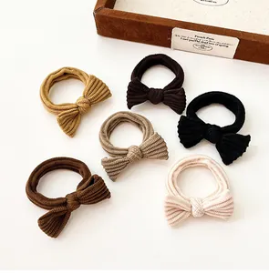 Flat lay of six ribbed bow hair ties in earth tones including beige and brown colors