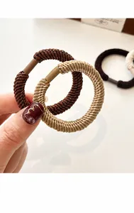 Close-up of thick elastic braided hair ties showing durable spiral texture and earthy tones