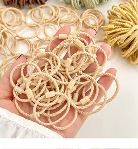 Detail of woven elastic hair bands in nude and earthy tones with square clips