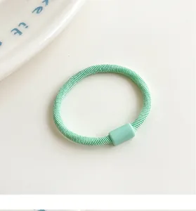 Detailed macro view of mint green high-elasticity hair tie with spiral texture and bead