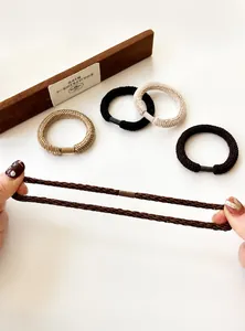 Detail showing elastic braided hair ties in five neutral colors with durable metal connectors