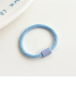 Macro detail of sky blue ribbed elastic hair tie with a light purple decorative buckle