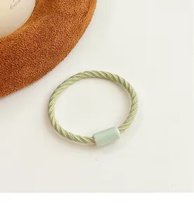 Detailed macro view of light green elastic hair tie with twisted texture and resin buckle