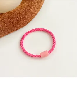 Detailed macro view of pink spiral elastic hair tie with rectangular plastic bead buckle