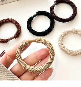 Close-up of thick braided hair ties in five earth tones showing ribbed texture and matte clips