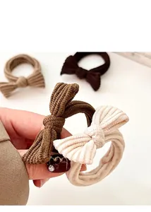 Close-up of bow knot hair ties in earth-toned ribbed fabric with elastic structure
