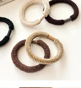 Detailed macro of thick woven elastic hair ties in five earth tones with durable matte joints