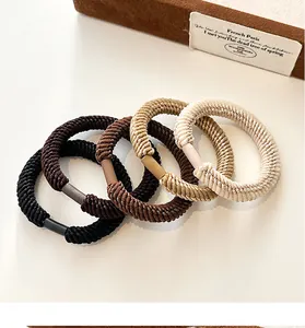 Close-up of four thick elastic ribbed hair ties in black, brown, khaki, and beige colors