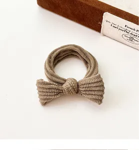 Close-up of ribbed knit texture on coffee-colored bow hair tie with durable elastic
