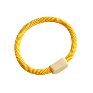 Elastic yellow hair tie for kids featuring a spiral texture and beige rectangle buckle