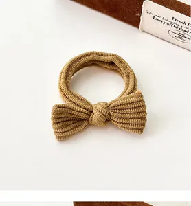 Close-up of a coffee-colored bow hair tie with premium ribbed texture and durable elastic band