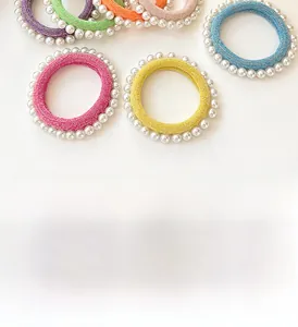 Détail de chouchous élastiques colorés ornés de perles blanches en diverses couleurs