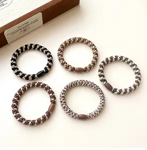 Detailed view of five multi-colored woven elastic hair ties with oval connector beads