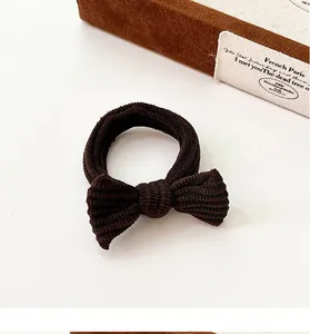 Detailed view of coffee brown bow hair tie featuring a textured ribbed knit fabric