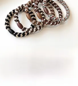 Close-up of five thick elastic braided hair ties in neutral earth tones with oval beads
