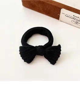 Detail of black ribbed knit bow hair tie showing high-elastic texture and premium design