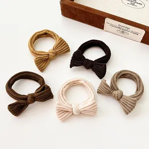 Set of 5 minimalist coffee-tone bow hair ties in elastic ribbed fabric on white background