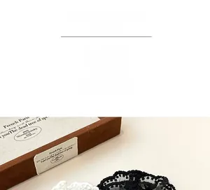 Close-up of double-layer lace hair ties in black and white inside a vintage wooden box