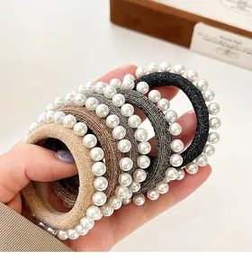 Gros plan détaillé d'élastiques à cheveux tissés ornés de perles blanches élégantes