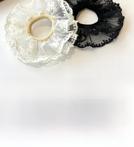 Detail of black and white double-layered lace hair scrunchies with fluffy mesh texture