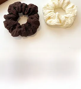 Detailed close-up of puff scrunchies in brown and cream colors with crinkle texture
