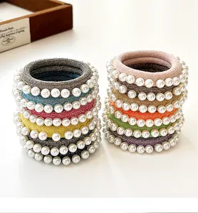 Détail de chouchous élastiques colorés avec tissu tissé et ornements en perles blanches