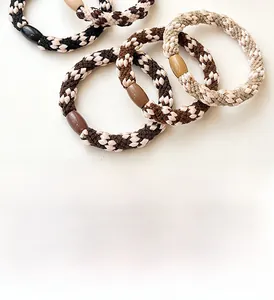 Detail of checkered braided elastic hair ties with smooth oval resin beads in earth tones