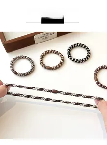 Detail of high-elastic braided hair ties showing strong stretch and coffee resin bead