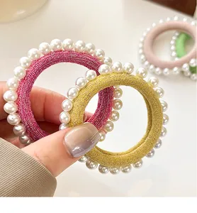 Détail de chouchous haute élasticité avec soie brillante et perles élégantes aux tons doux