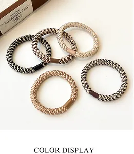 Detail of five thick elastic hair ties in neutral tones with durable cylinder joints
