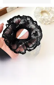 Close-up of black double-layered lace hair scrunchie with elegant floral embroidery texture