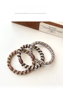 Close-up of elastic woven hair ties in coffee tones with smooth decorative buckles