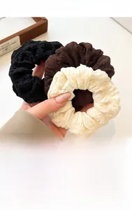 Three-pack elastic puff scrunchies in black, coffee, and beige on wooden tray decor