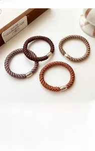 Close-up of high-elastic braided hair ties in coffee tones with gold metal buckles