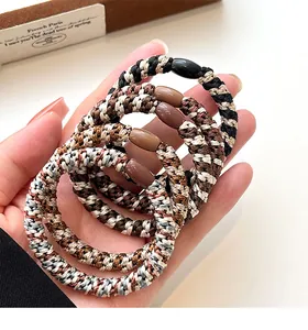 Close-up of elastic woven hair ties in earth tones with smooth resin bead detail