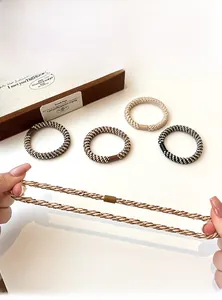 Close-up of flexible elastic hair ties being stretched showing durability and braided texture