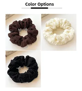 Detailed texture of ruffled puff scrunchies in brown, cream, and black colors