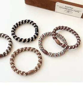 Close-up of high-elasticity braided hair ties with resin buckles in coffee shades